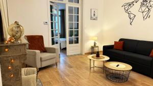 a living room with a couch and chairs and a table at Appartement Villa Les Lilas in Dunkerque
