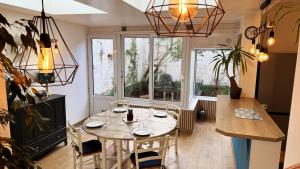 a dining room with a table and chairs and a window at Appartement Villa Les Lilas in Dunkerque