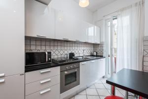 a kitchen with white cabinets and a black microwave at Olimpic Vatican Home in Rome