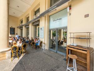 a group of people sitting at tables outside a restaurant at P&O Apartments Plac Zbawiciela in Warsaw