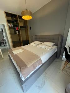 a large bed in a room with a lamp at Anais apartment in Preveza