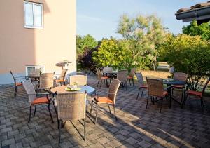 a group of tables and chairs on a patio at Fairway Hotel in Sankt Leon-Rot