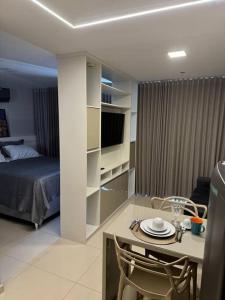 a bedroom with a bed and a table with a dining room at Apartamento dentro do shopping águas claras, Lindo in Taguatinga