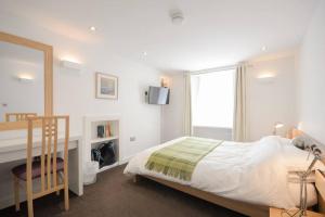 a bedroom with a bed and a desk and a mirror at No3 By The Sea a 5 Star Cozy Coastal Cottage in Saint Monance