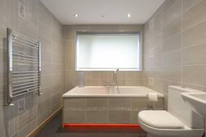 a bathroom with a sink and a toilet and a window at No3 By The Sea a 5 Star Cozy Coastal Cottage in Saint Monance