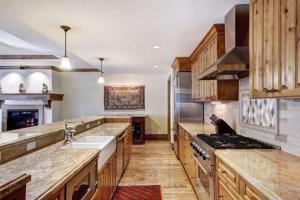 a large kitchen with a sink and a stove at Platinum 3 Bedroom Vacation Rental In The Heart Of Vail That Includes Ski Valet, Ski Deck, Rooftop Pool, Panoramic Views in Vail