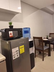 a television sitting on top of a refrigerator in a room at LUXURY CONDO STUDIO UNIT at 38 PARK AVENUE CEBU I T PARK in Tabok