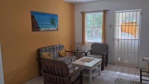 a living room with two chairs and a table at Happy Turtle Apartments in Willemstad
