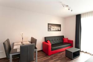 a living room with a red couch and a table at Sofia Top Lux Apartment in Sofia +12 photos