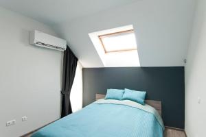 a bedroom with a bed with blue sheets and a window at Sofia Top Apartments in Sofia