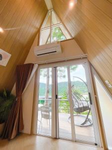 a room with a glass door with a balcony at บ้านผูกรัก ทะเลหมอก ณ เขาค้อ in Khao Kho
