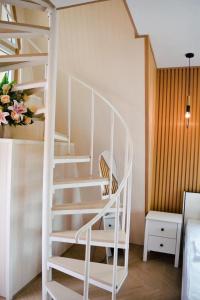 a white spiral staircase in a room with a bed at บ้านผูกรัก ทะเลหมอก ณ เขาค้อ in Khao Kho