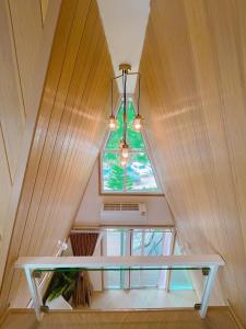 a table in a room with a window and a chandelier at บ้านผูกรัก ทะเลหมอก ณ เขาค้อ in Khao Kho