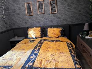 a bedroom with a bed with a yellow comforter at Veluwe Park Reewold Chalet Vision in Putten