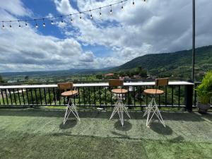 a table and chairs on a balcony with a view at บ้านผูกรัก ทะเลหมอก ณ เขาค้อ in Khao Kho