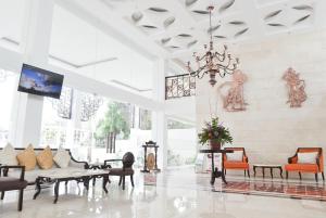 a living room with a chandelier and tables and chairs at LYNN Hotel by Horison in Yogyakarta