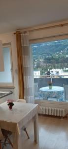 a living room with a large window with a table at Merano Panoramablick ruhig gelegen in Merano