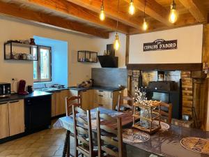 a kitchen with a table and chairs and a stove at Gîte Charmant La Combette in Thouron