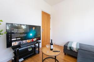 a living room with a large flat screen tv at Ealing 3 Bath Flat with Parking 10 mins to Station in Ealing