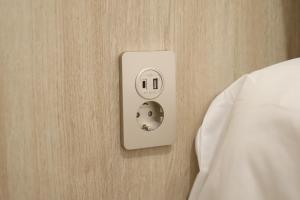 a lightswitch on a wall next to a bed at Manso Hostel in DDP in Seoul