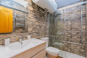 a bathroom with a toilet and a sink and a shower at Sierra Nevada apartamento de madera muy cálido con buenas vistas y WiFi in Sierra Nevada +14 photos