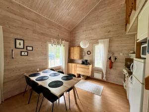 a dining room with a table and a refrigerator at Usva Cabins Levi - Niestapirtti B in Kittilä
