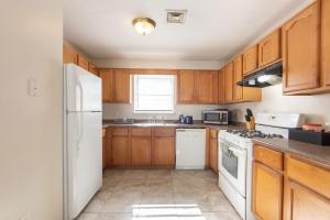 a kitchen with wooden cabinets and white appliances at 4 Bedroom-Airport Convient in University of Medicine and Dentistry Rooftop Heliport