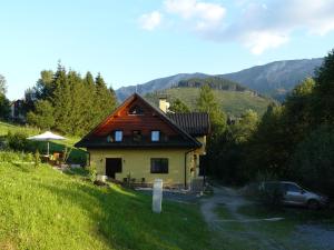 a house on a hill with a car parked next to it at Privát Za Lesíkom in Ždiar