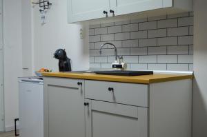 a kitchen with white cabinets and a sink at LevelUP in Đakovo