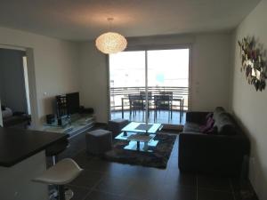 ein Wohnzimmer mit Sofa und Tisch in der Unterkunft Appartement vue mer - 2ch 2sdb - Parking - Vue splendide mer et montagne in Calvi