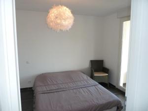 ein Schlafzimmer mit einem Bett und einem Kronleuchter in der Unterkunft Appartement vue mer - 2ch 2sdb - Parking - Vue splendide mer et montagne in Calvi