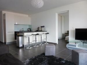 eine Küche mit Theke und Hockern in einem Wohnzimmer in der Unterkunft Appartement vue mer - 2ch 2sdb - Parking - Vue splendide mer et montagne in Calvi