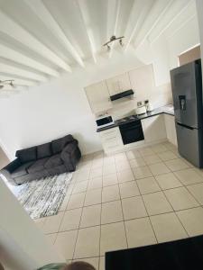 a kitchen with a couch and a refrigerator at Luxury Suites at St Petes Duplex Townhouse in Newton Park