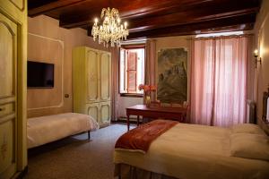 sypialnia z dwoma łóżkami i żyrandolem w obiekcie Menhir Rooms w mieście Campobasso