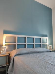 a bedroom with a large bed with a blue wall at Villa Carmela in Martina Franca