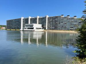 un grand bâtiment à côté d'une masse d'eau dans l'établissement Laguna Beach appart dans résidence avec piscine, à Knokke-Heist