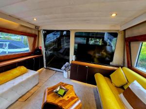 a living room with a yellow couch and a tv at Rhapsody in Blue in Chertsey