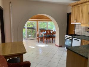 a kitchen with a table and a dining room at Magdaléna Vendégház in Aba