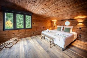una camera da letto con un letto in una stanza di legno di Chalet La Perle Verte, luxe, piscine, spa et sauna a Gérardmer Altre 40 foto