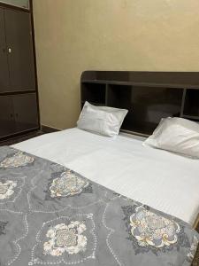 a bed with white sheets and pillows on it at Sudama ki Kuttiyaa in Ayodhya