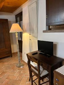 a desk with a computer and a lamp in a room at Al Castello in Tavullia +11 photos