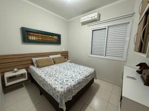 Un dormitorio pequeño con una cama y una ventana. en Apartamento lindo na praia da enseada - Ubatuba, en Ubatuba 20 fotos más