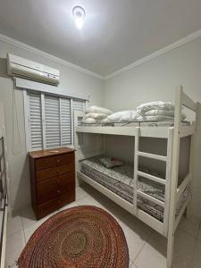 1 dormitorio con 2 literas y alfombra en Apartamento lindo na praia da enseada - Ubatuba, en Ubatuba