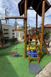 un parque infantil con escalera y columpio en Apartamento lindo na praia da enseada - Ubatuba, en Ubatuba