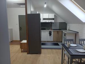 una cocina con escalera y una habitación con mesa en Sunny Grey, en Żerniki Wroctawskie 12 fotos más