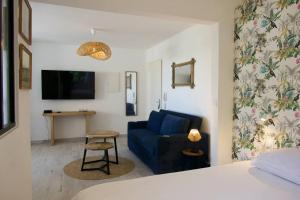 Una sala de estar con un sofá azul y una mesa. en Studio Centre-Ville Saint Gilles Les Bains, en Saint-Gilles-les-Bains