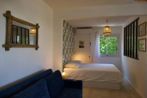 Un dormitorio con una cama y un sofá azul. en Studio Centre-Ville Saint Gilles Les Bains, en Saint-Gilles-les-Bains