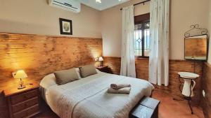 ein Schlafzimmer mit einem großen Bett mit einer Holzwand in der Unterkunft Villa 15 by Villamya in El Gastor + 14 Fotos