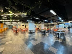 a large room with tables and chairs in a building at Kuching Cozy Comfort 02 - Kozi Square Studio in Kuching