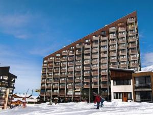 a large building in the snow with people in front of it at Appartement confort pour 5 aux Menuires - Animaux admis - FR-1-452-41 in Les Menuires